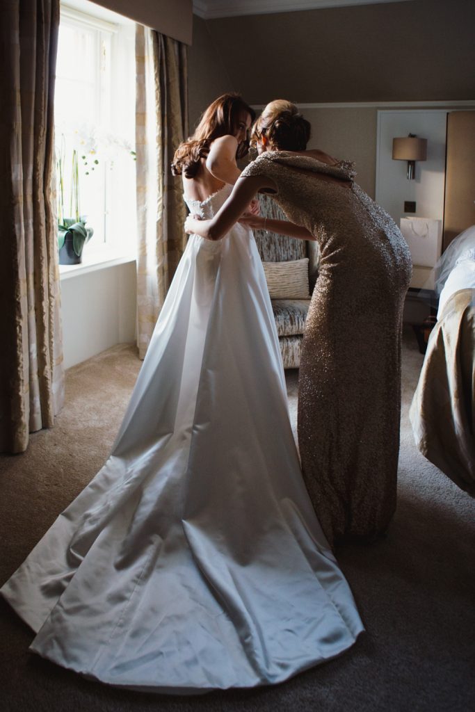 Bridal preparation by Cheshire Wedding Photographer. Featuring a Suzanne Neville gown.