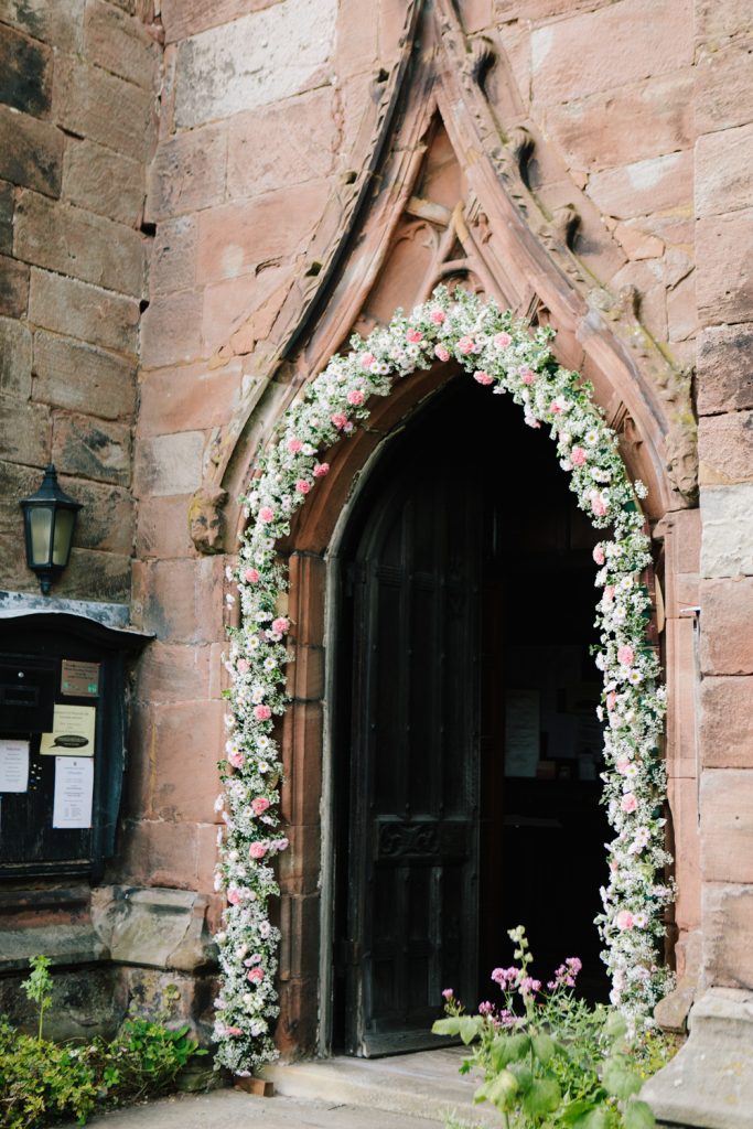 Acton Church in Nantwich with flower arch for a Dorfold Hall church wedding ceremony.