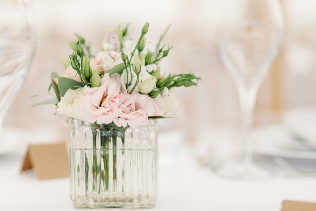 Table details by Cheshire wedding photographer at a Dorfold Hall wedding. Pretty rustic florals featuring roses and hydrangeas.