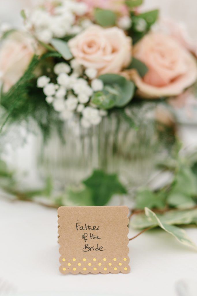 Table details by Cheshire wedding photographer at a Dorfold Hall wedding. Pretty rustic florals featuring roses and hydrangeas.
