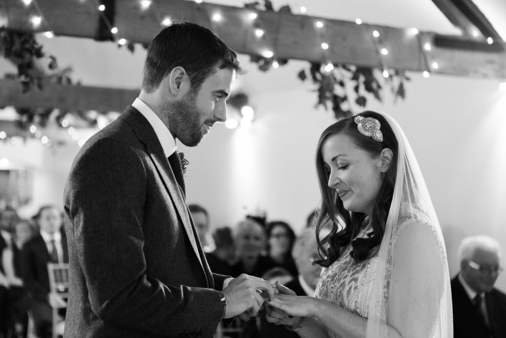 Black and white documentary wedding photography for a winter barn wedding ceremony .