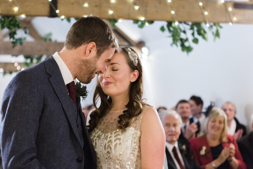 Glamorous winter barn wedding ceremony with bride in Jenny Packham gown.