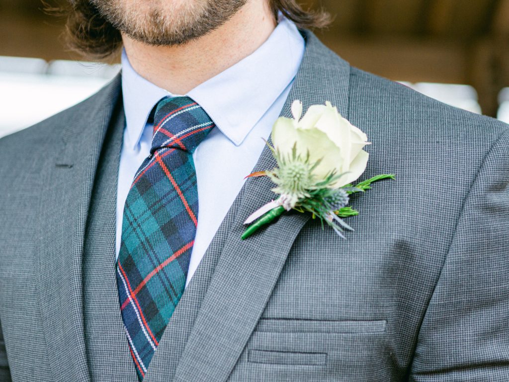 Groom wearing family tartan tie for wedding at Iscoyd Park