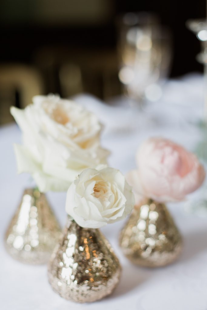 Roses in small gold vases for wedding at Sandon Hall by Staffordshire wedding photographer