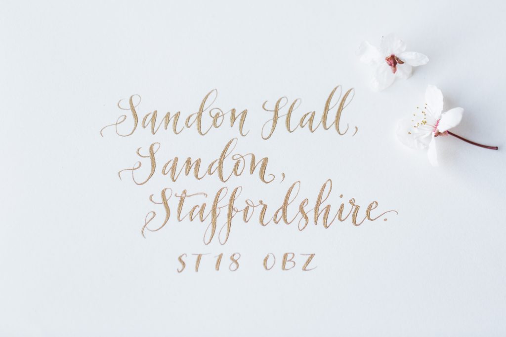 Gold calligraphy for wedding invitations from a bridal inspiration shoot at Sandon Hall. Wedding details captured by fine art documentary wedding photographer Jade Osborne Photography.