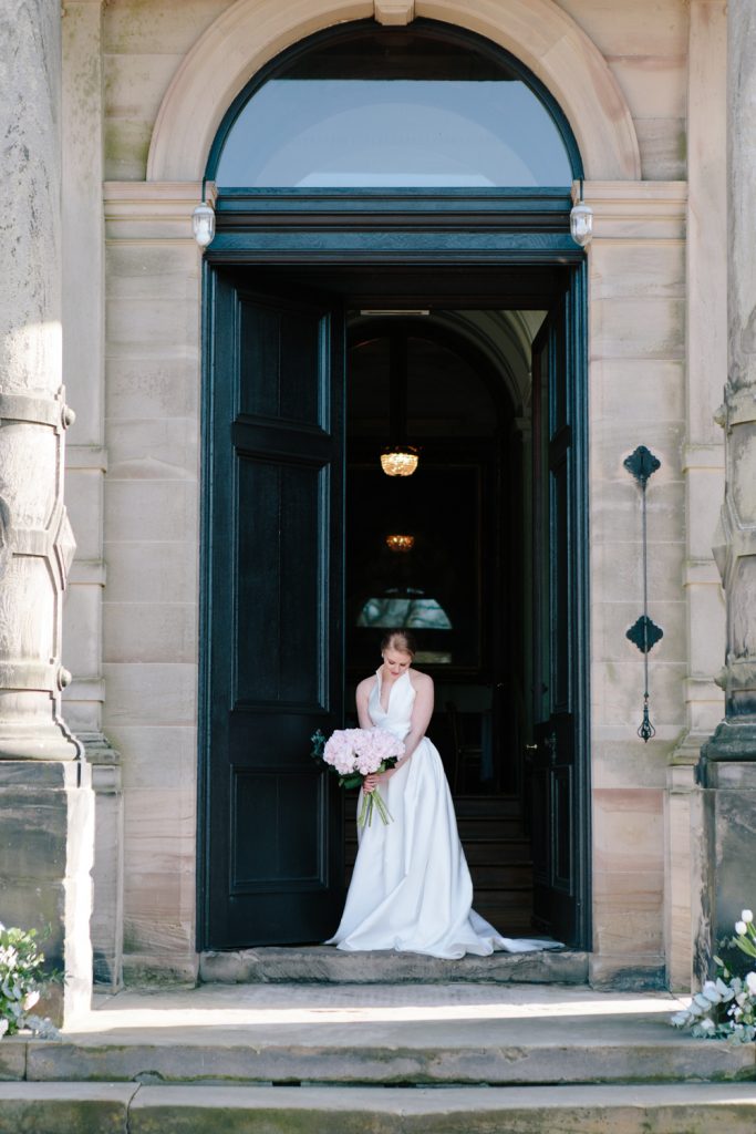 Bride at the door of Sandon Hall, wedding venue in Staffordshire for this bridal inspiration shoot featuring a Jesus Peiro wedding gown. Photography by Jade Osborne Fine art wedding photographer.