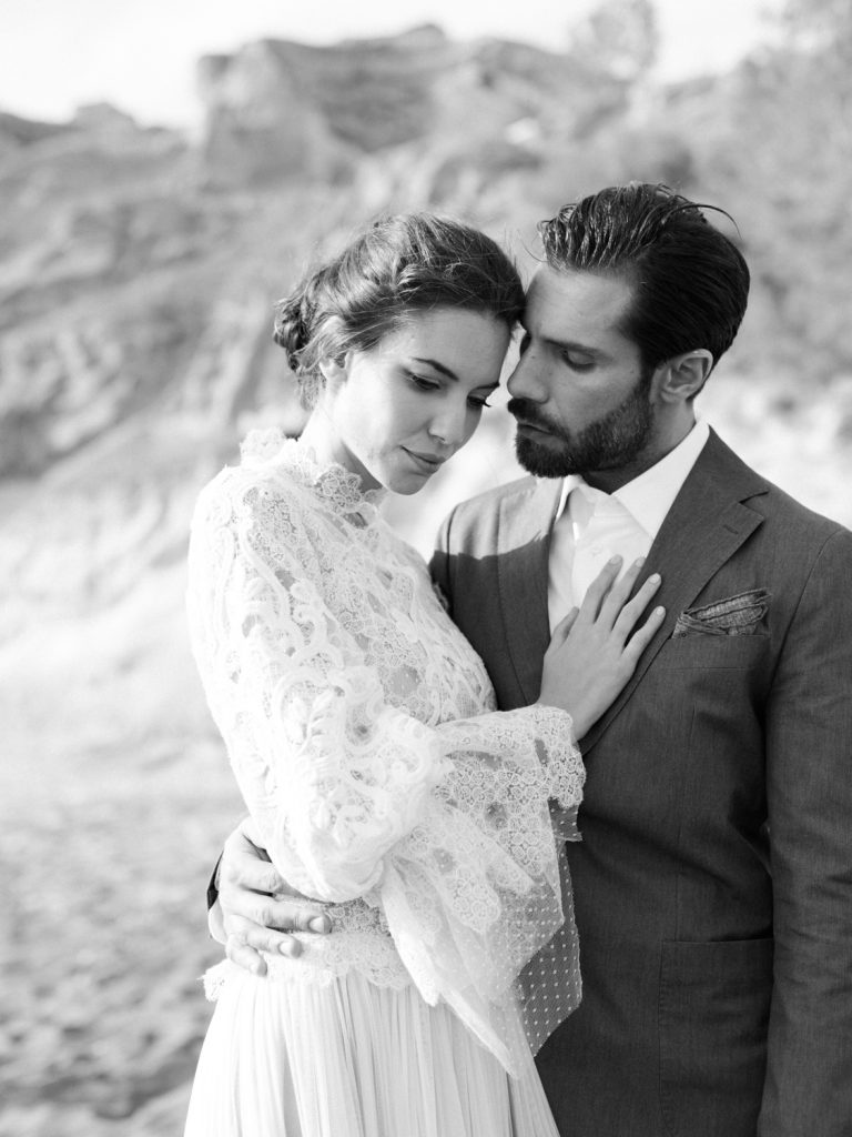Fine art wedding photography featuring black and white photo of bride and groom on the beach by UK based wedding photographer