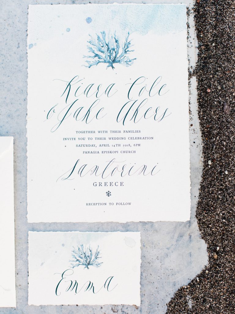 Stationery for a beach wedding in Santorini featuring white and blue calligraphy
