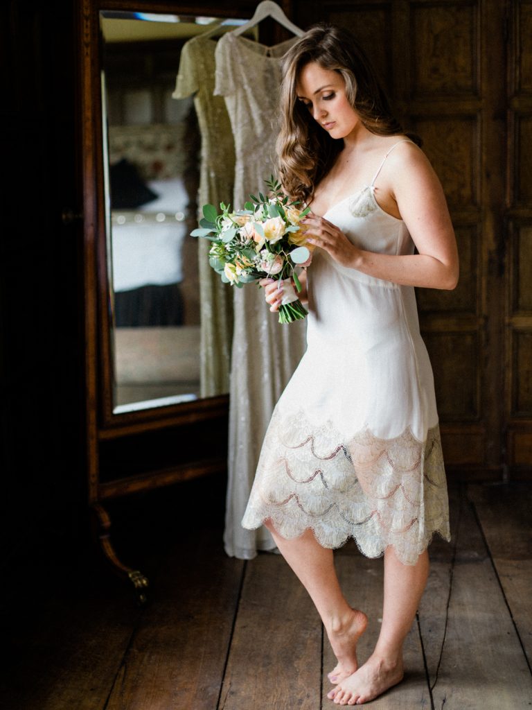 Bridal preparatrion at Dorfold Hall. Bride wearing Shell Belle Couture ivory lace and gold slip with bridal bouquet by Flowers by Breige.