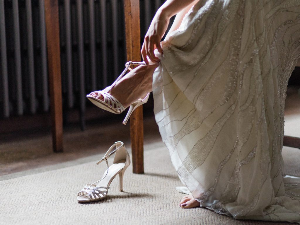 Bride getting ready and putting on her shoes for an inspiration shoot at Dorfold Hall in Cheshire.