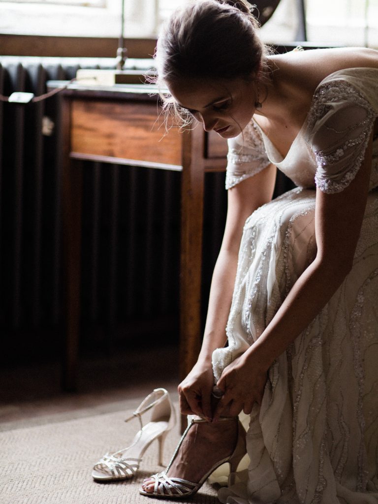 Bride getting ready and putting on her shoes for an inspiration shoot at Dorfold Hall in Cheshire.