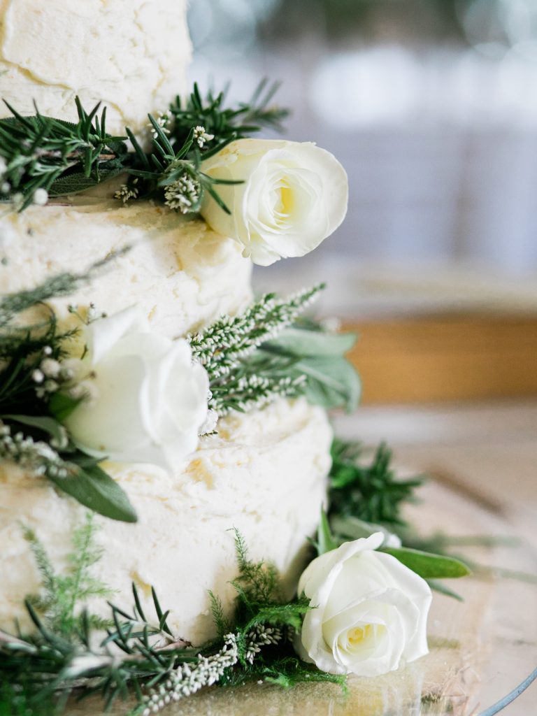 Rustic wedding cake with white flowers by UK Fine Art Wedding Photographer