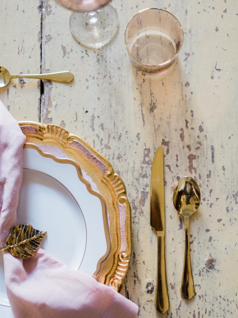 Vintage gold plates and cutlery for a Belle Epoque wedding in Santorini