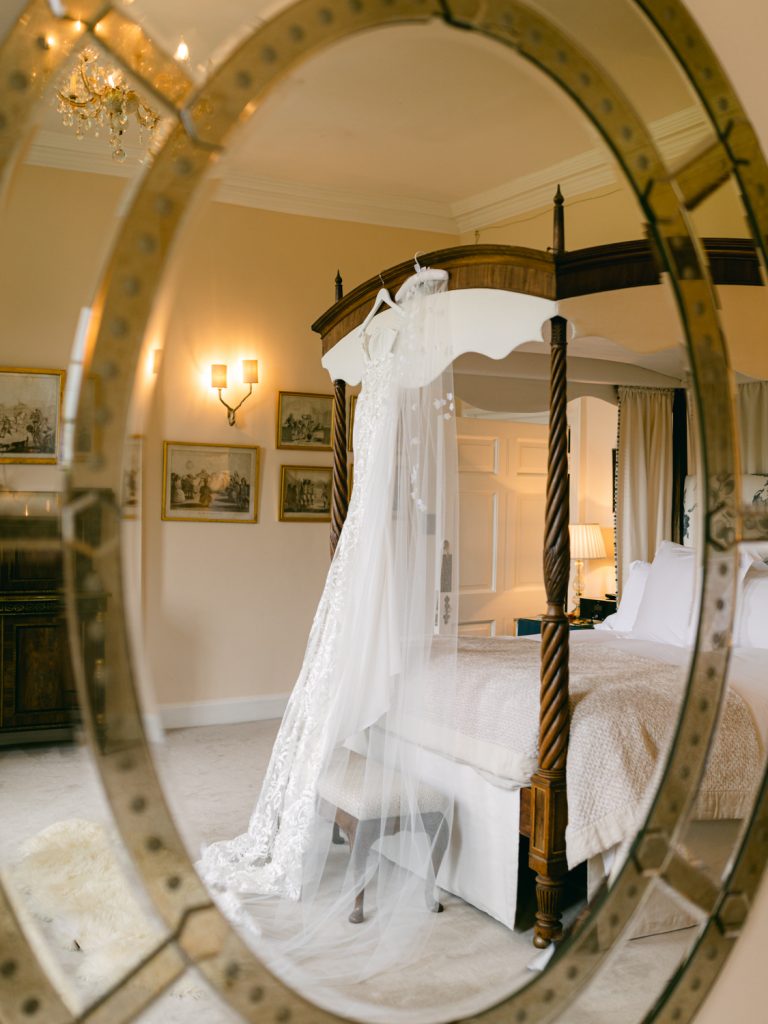 Mirror shot, focusing on the bridal veil hanging on the four poster bed