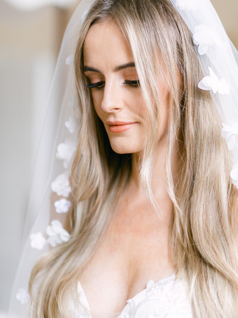 Close up of Erin dressed and ready for the ceremony with natural make up, hair down and veil loose around her shoulders.