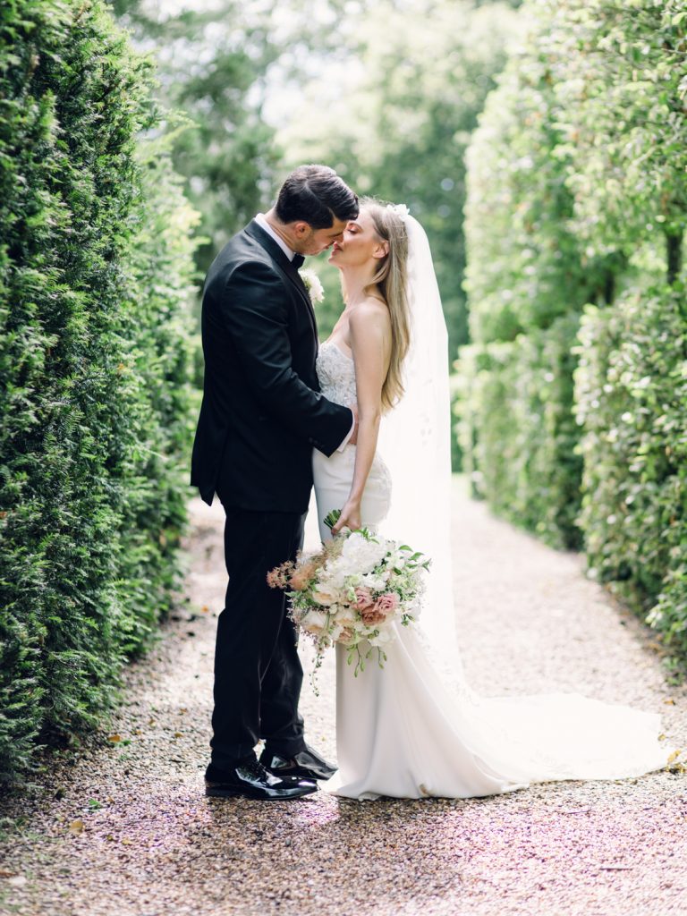 Newlyweds Erin and Ryan kissing in the gardens at Iscoyd Park. Lots of bright natural light and greenery.