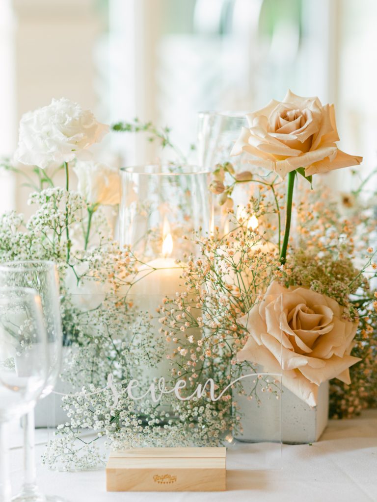 Detail shot of the wedding breakfast table decor. Featuring roses, gypsophila and candles.