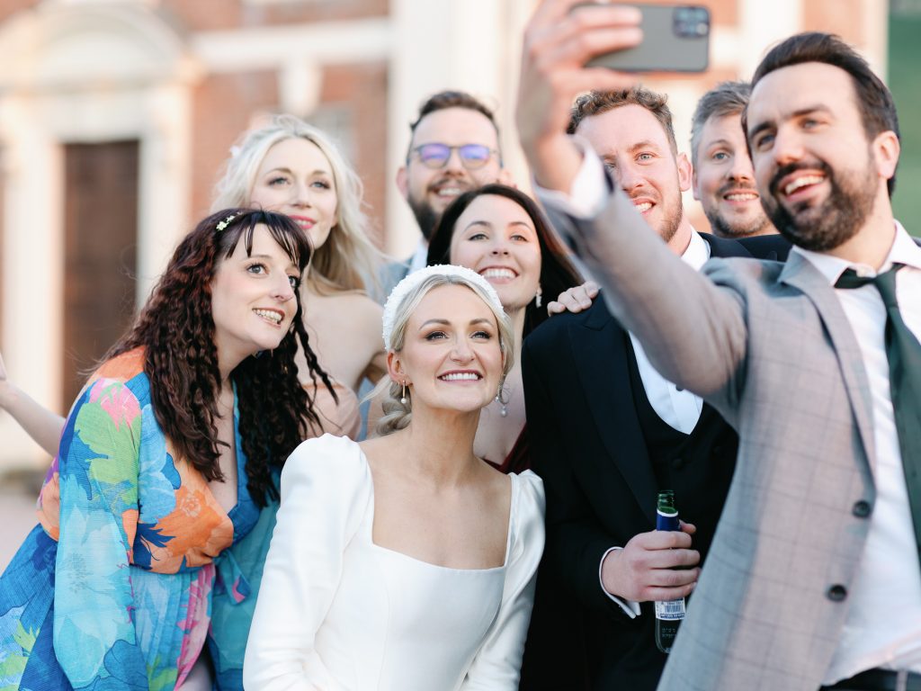 Bride having a selfie taken with some wedding guests.