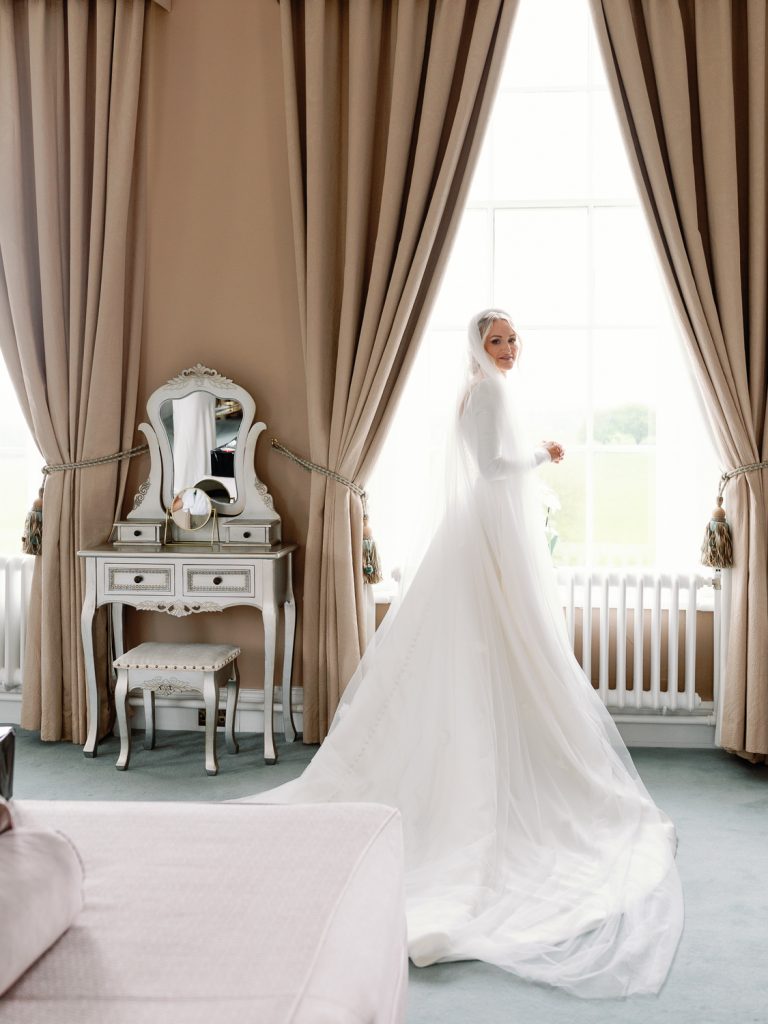 Bride Jessica standing at the window of the Honeymoon Suite