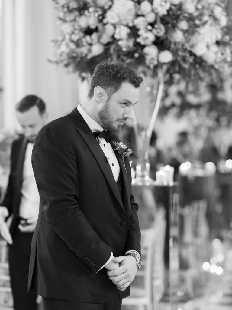 Nervous groom waiting at the bottom of the aisle.