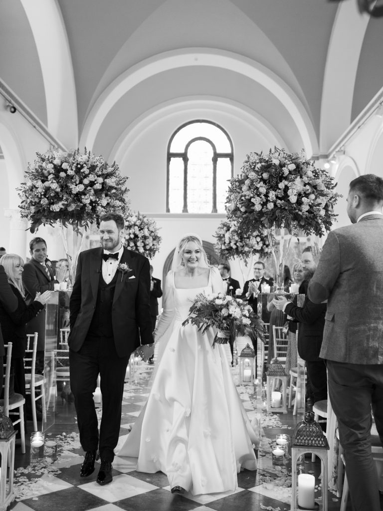 Bride and groom walking back down the aisle together after getting married.