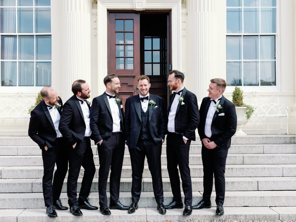 Groom Lewis and his groomsmen gathered on the steps of Hawkstone Hall