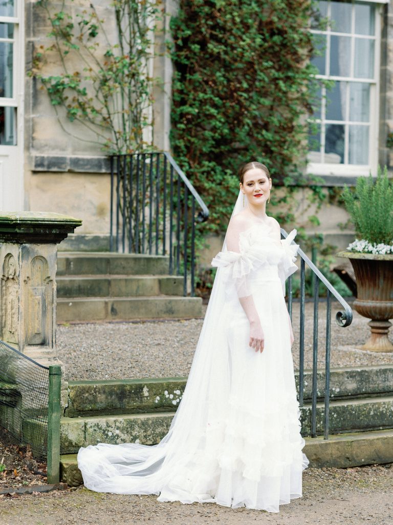 Bride Else standing outside Middleton Lodge next to the exterior steps.