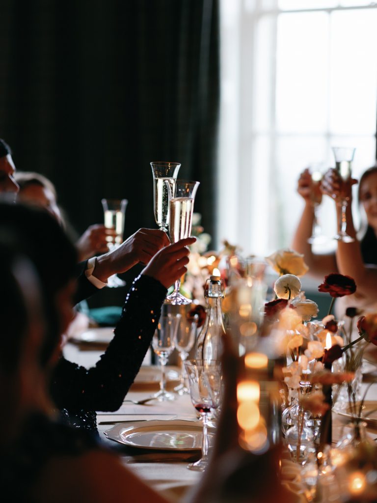 Cheers lifting their champagne glasses up to toast the newlyweds.